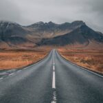 empty highway overlooking mountain under dark skies
