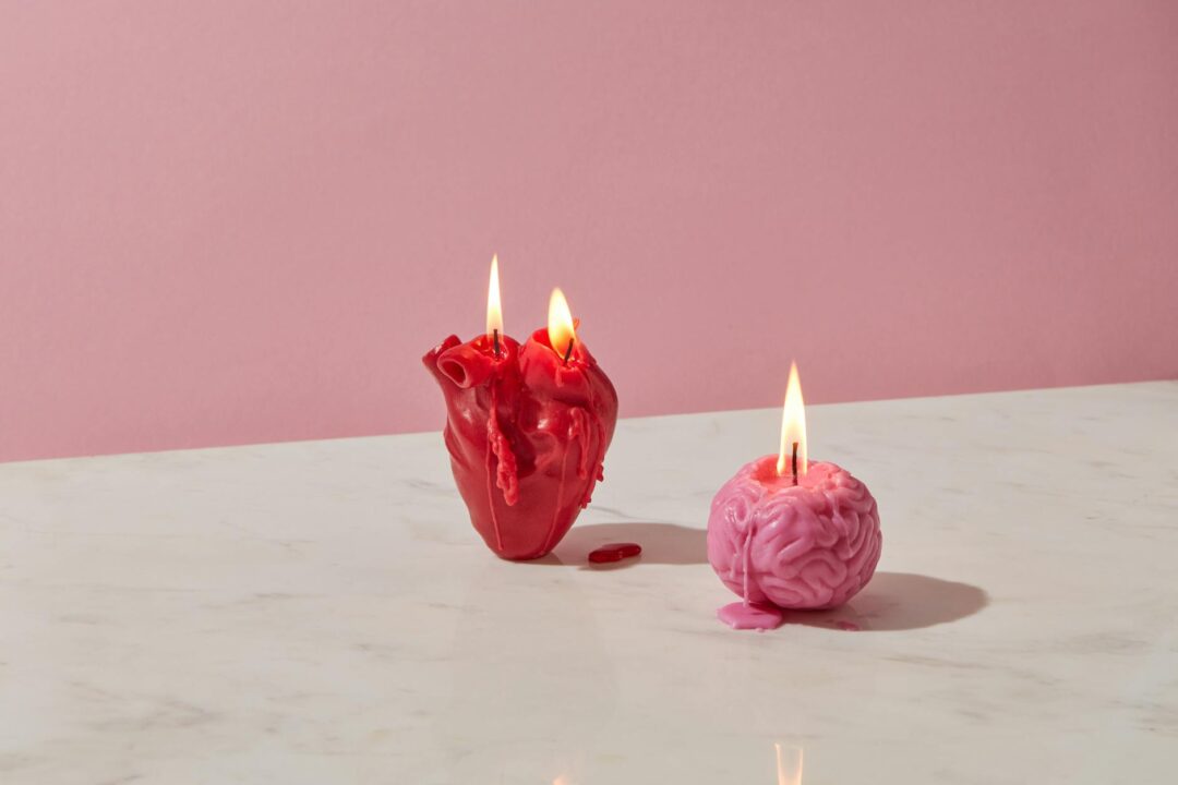 photograph of a heart candle beside a brain candle